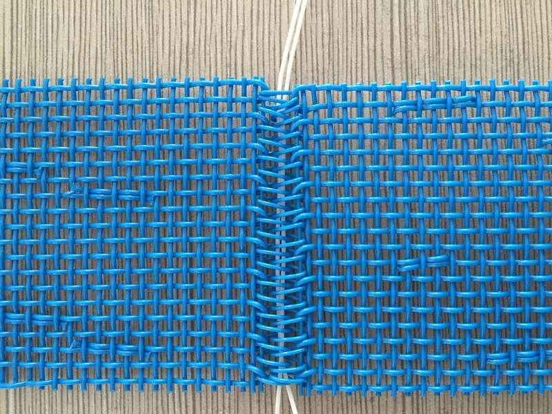 Self-loop seam woven from the mesh's own yarns on a square mesh belt
