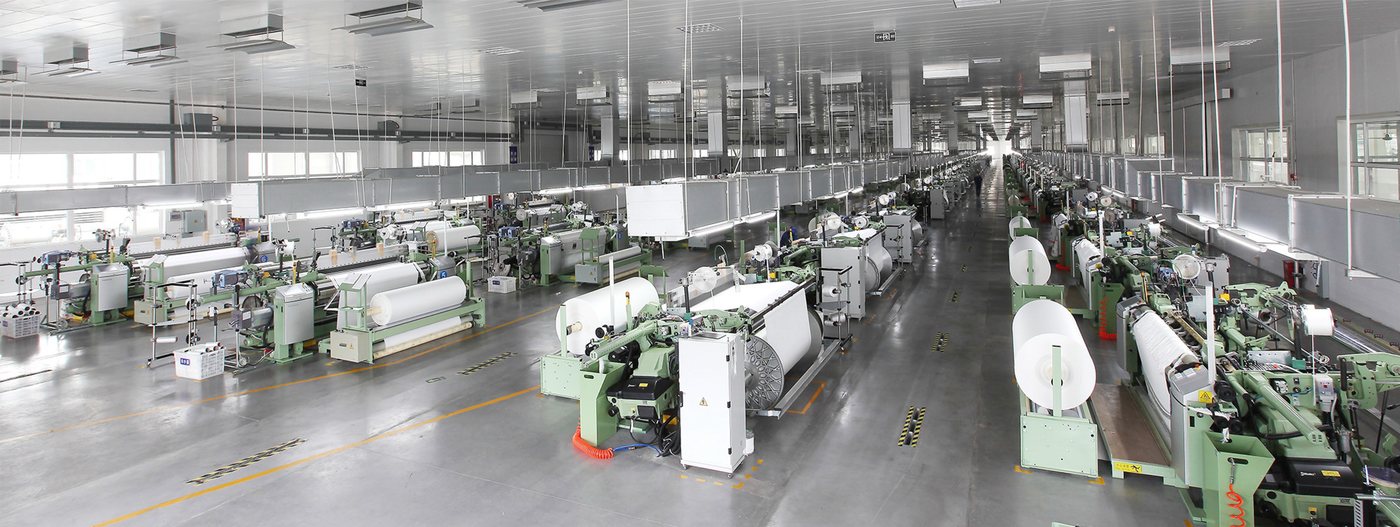 Panorama of the Aurora filter fabric weaving workshop with rows of looms