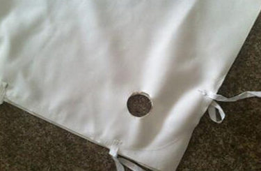 Corner tie fixing a press filter cloth to the plate